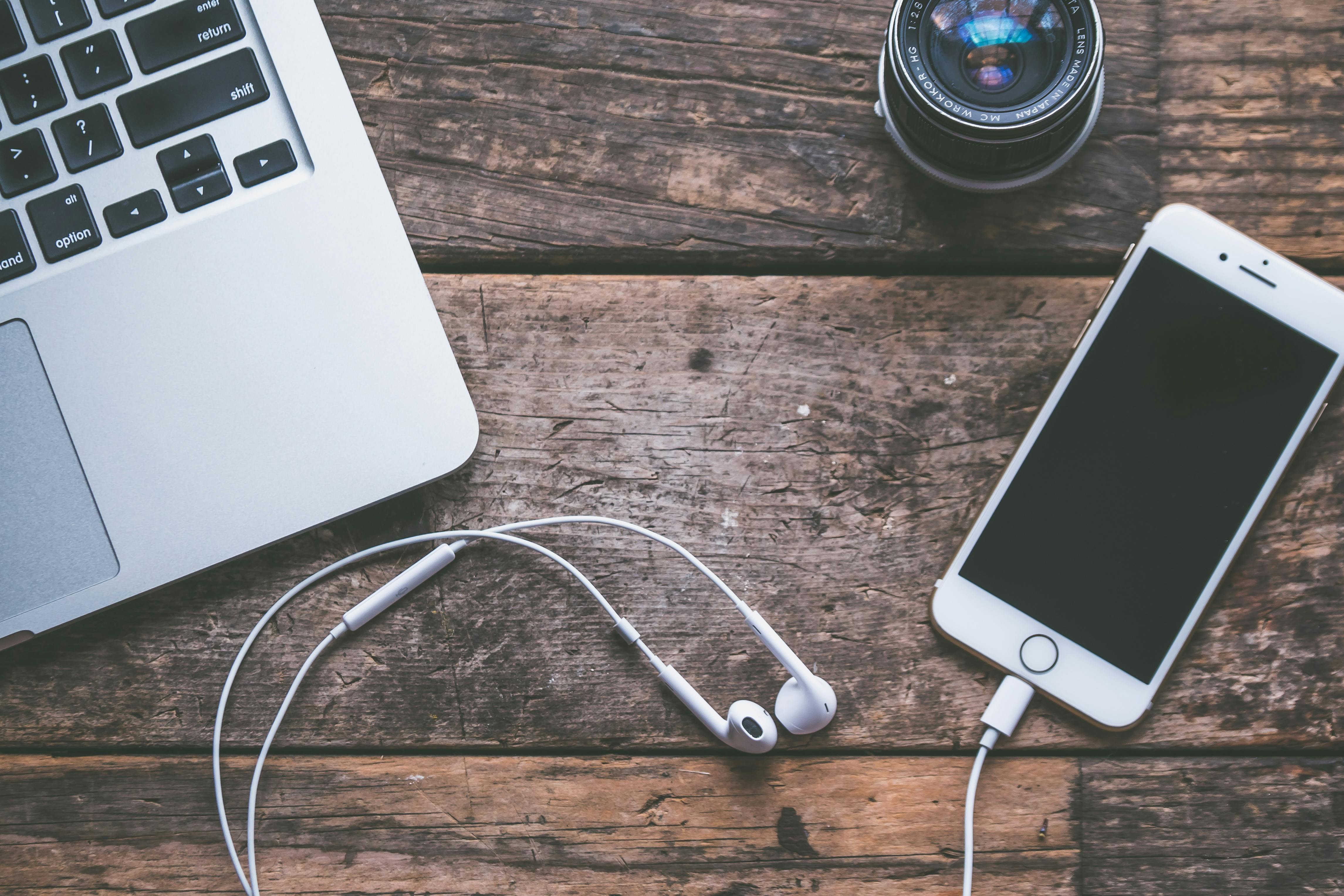 Teléfono, auriculares y portátil sobre una mesa
